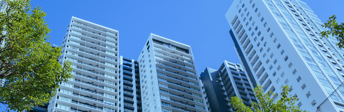 綺麗な青空に高層マンションが建ちそびえる写真
